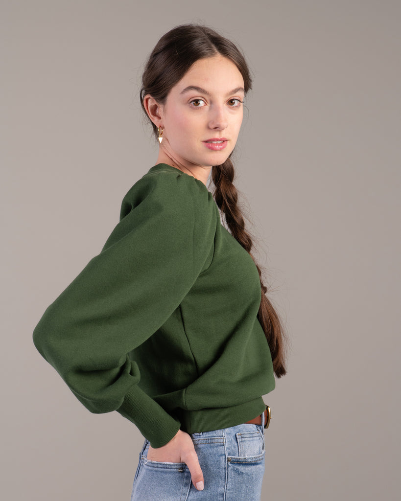 Woman in a green puffed shoulder sweatshirt