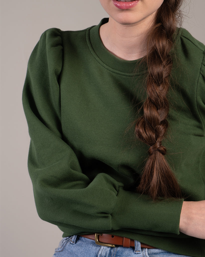 Woman in a green puffed shoulder sweatshirt