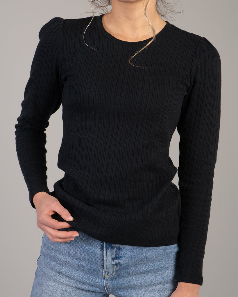 Woman in a black ribbed knit long sleeve tee