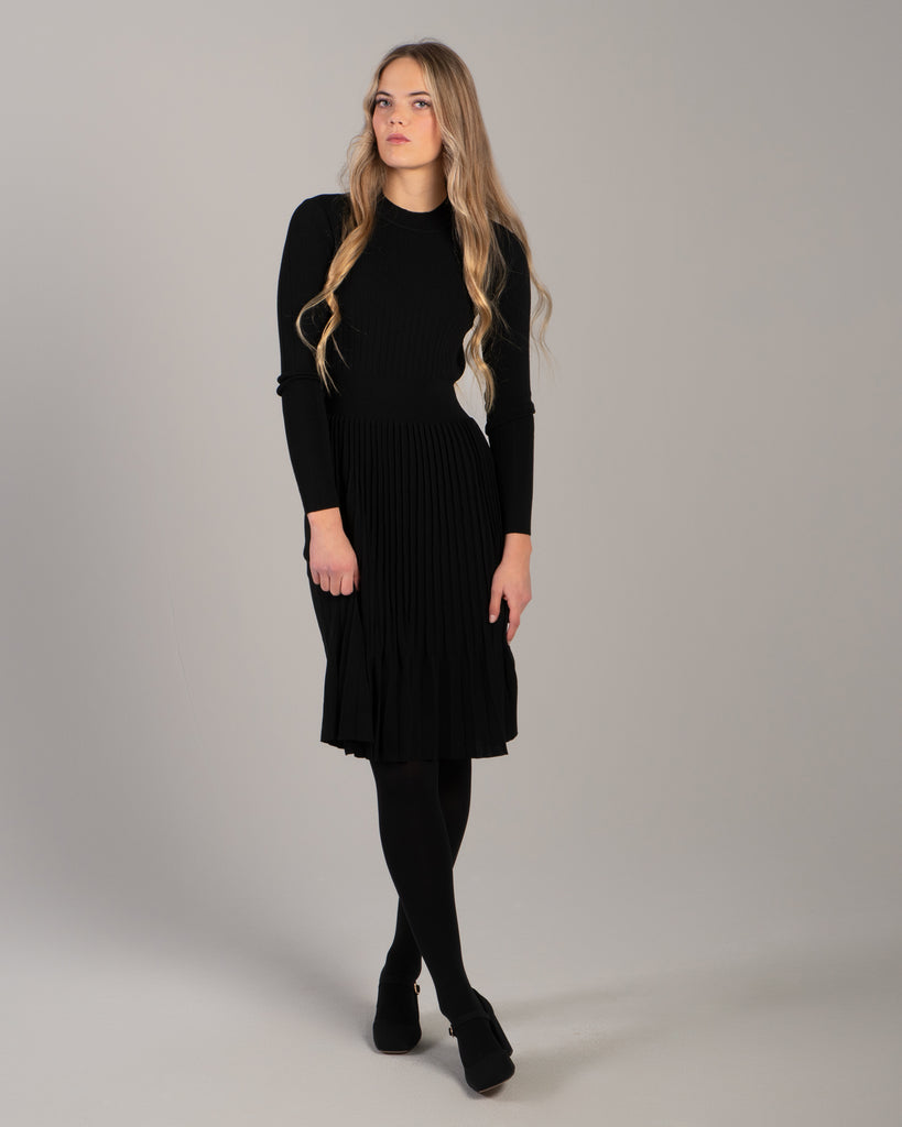 Woman in a black ribbed-knit long sleeve dress