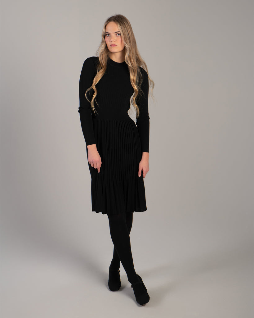 Woman in a black ribbed-knit long sleeve dress