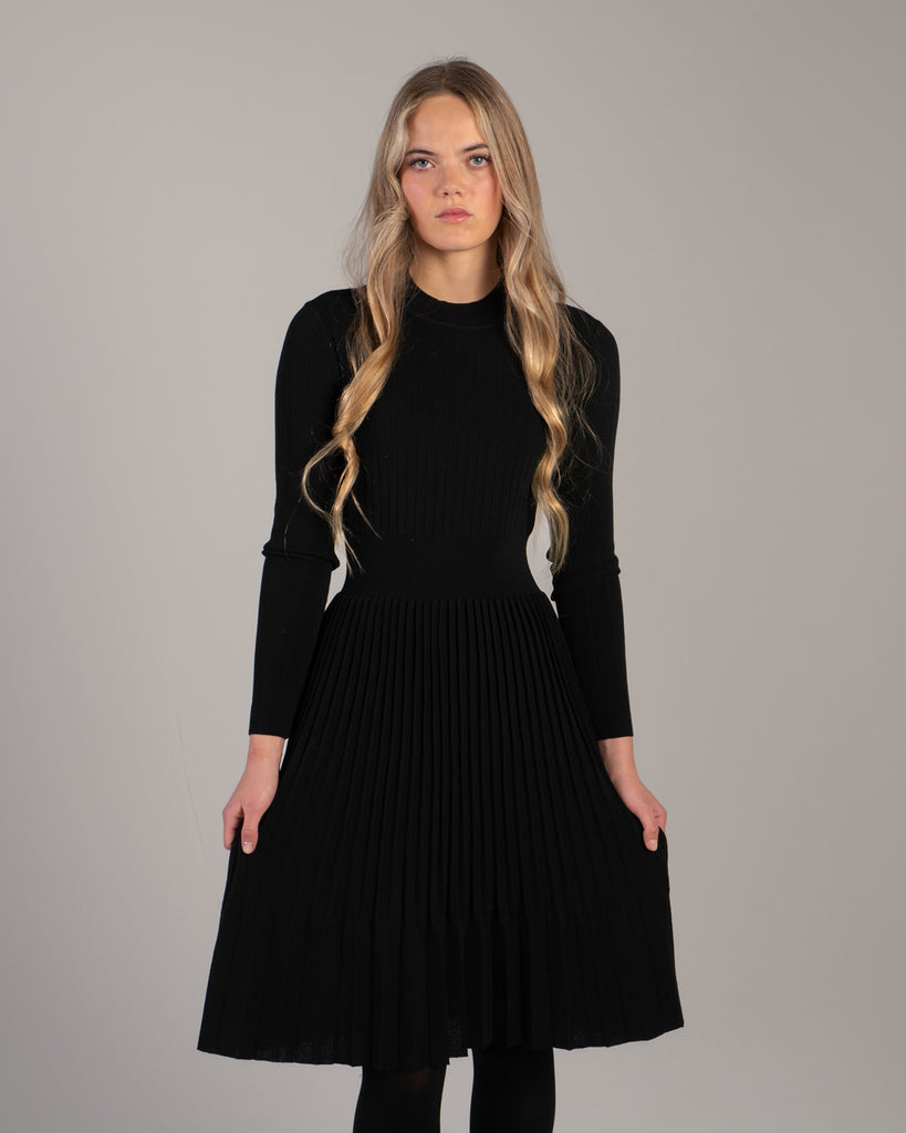 Woman in a black ribbed-knit long sleeve dress