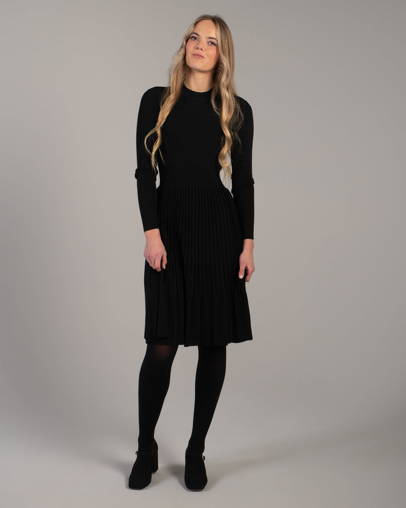 Woman in a black ribbed-knit long sleeve dress