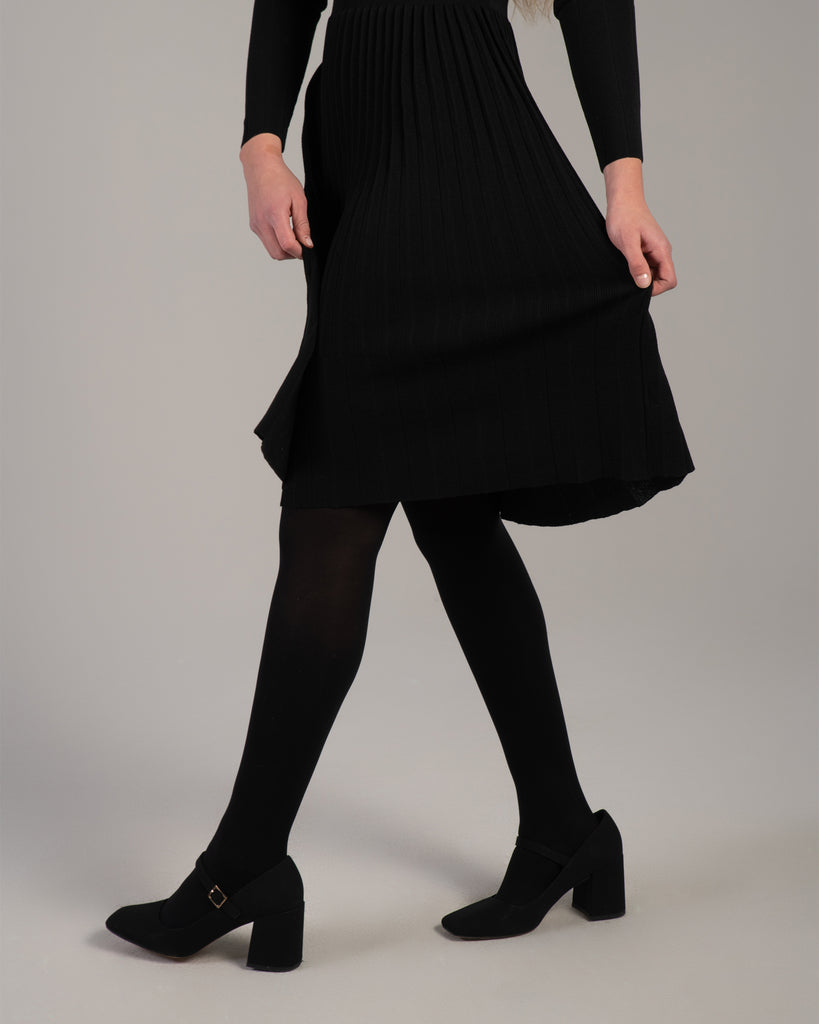 Woman in a black ribbed-knit long sleeve dress