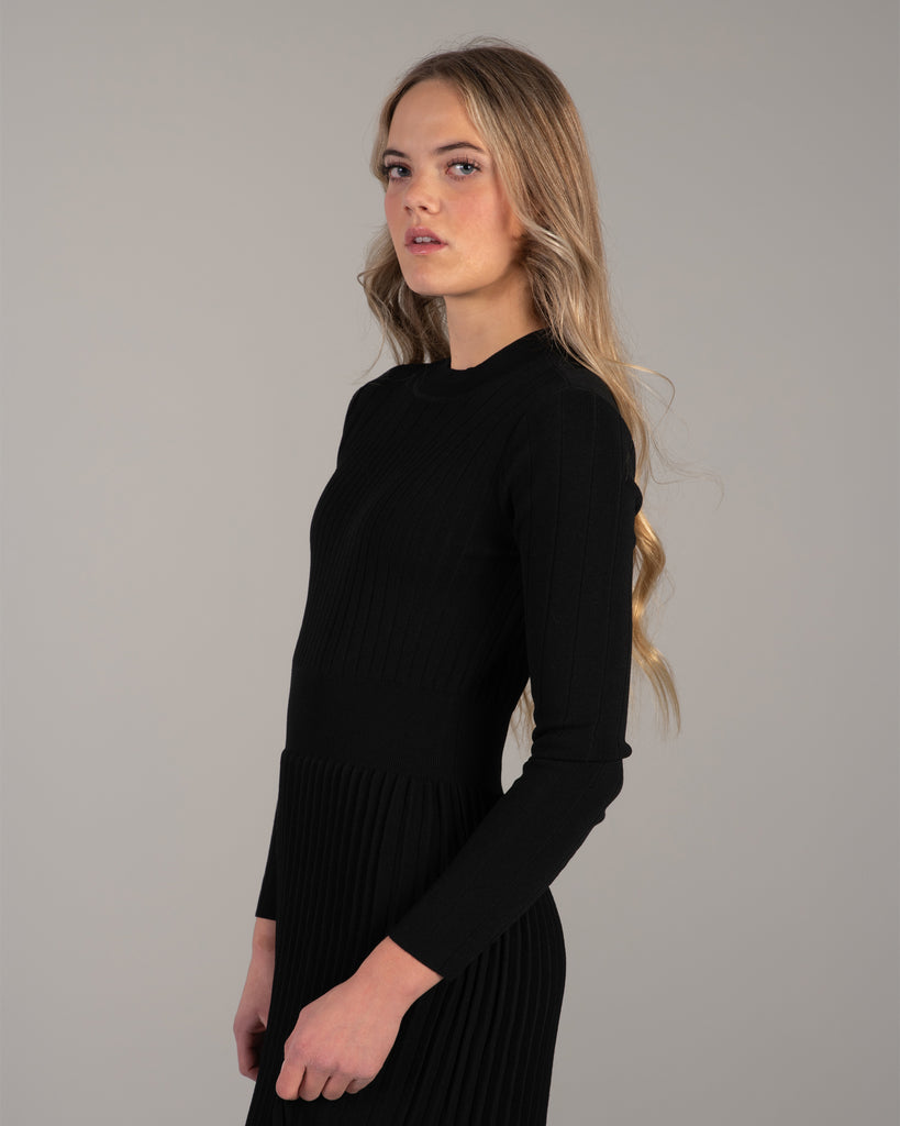 Woman in a black ribbed-knit long sleeve dress