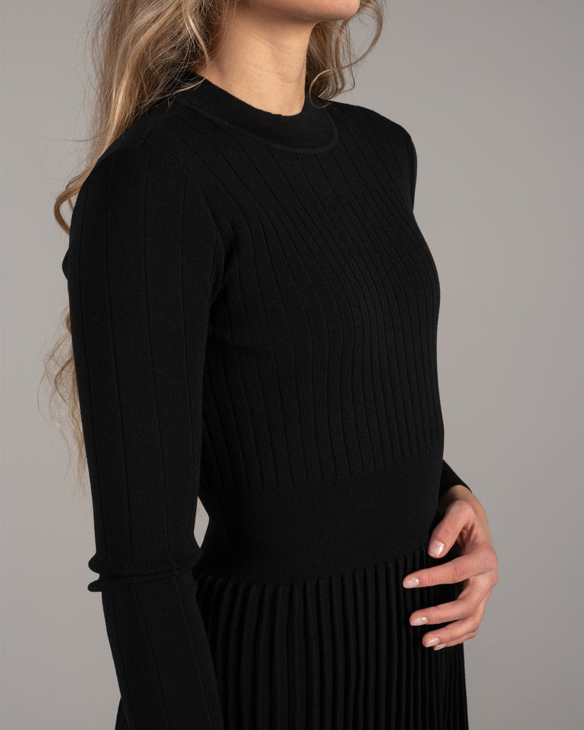 Woman in a black ribbed-knit long sleeve dress