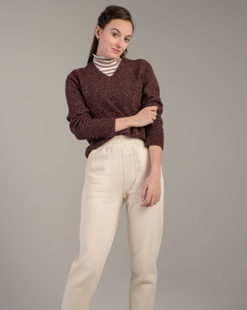 Model wearing a brown speckled long sleeve v-neck pullover sweater.