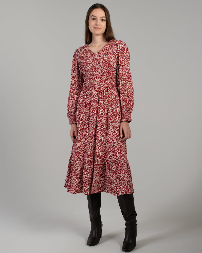 Woman in a red printed long sleeve midi-length dress