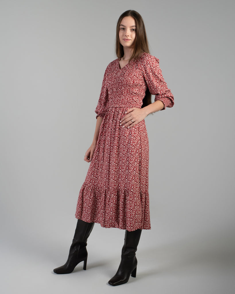 Woman in a red printed long sleeve midi-length dress