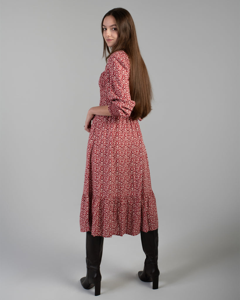 Woman in a red printed long sleeve midi-length dress