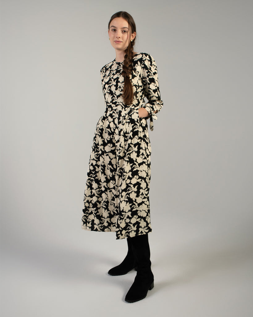 Woman in a black and white floral print, 3/4 sleeve midi length dress