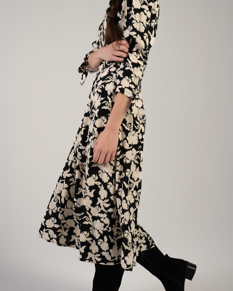 Woman in a black and white floral print, 3/4 sleeve midi length dress