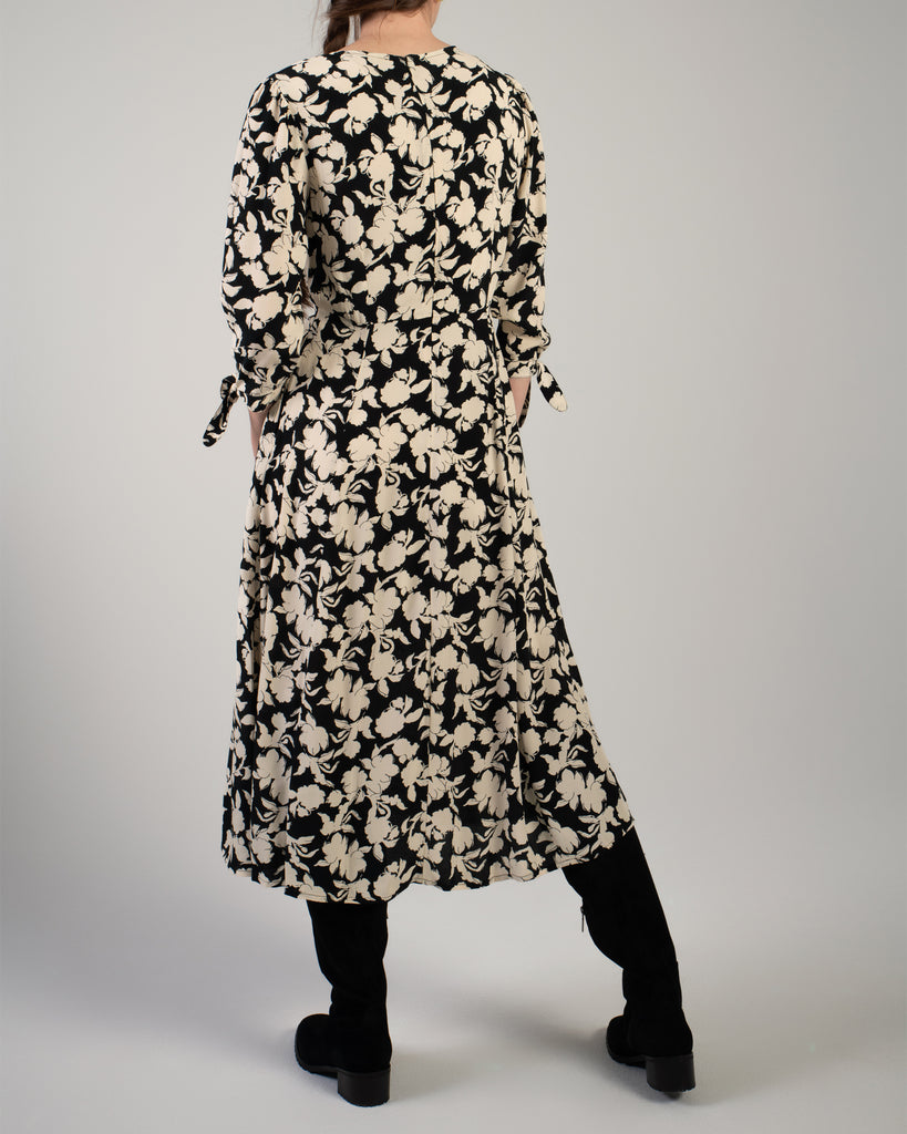 Woman in a black and white floral print, 3/4 sleeve midi length dress