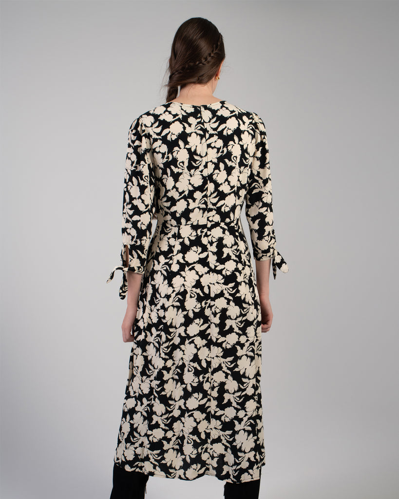 Woman in a black and white floral print, 3/4 sleeve midi length dress