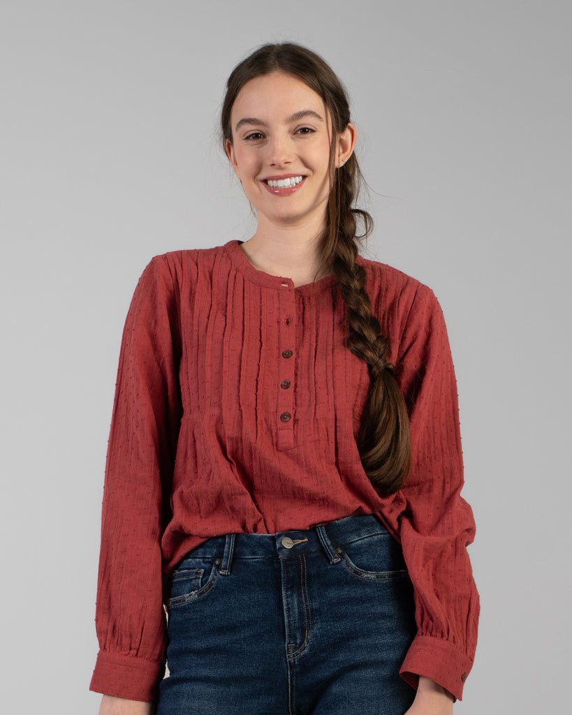 Woman in a red long sleeve blouse with dotted swiss detailing