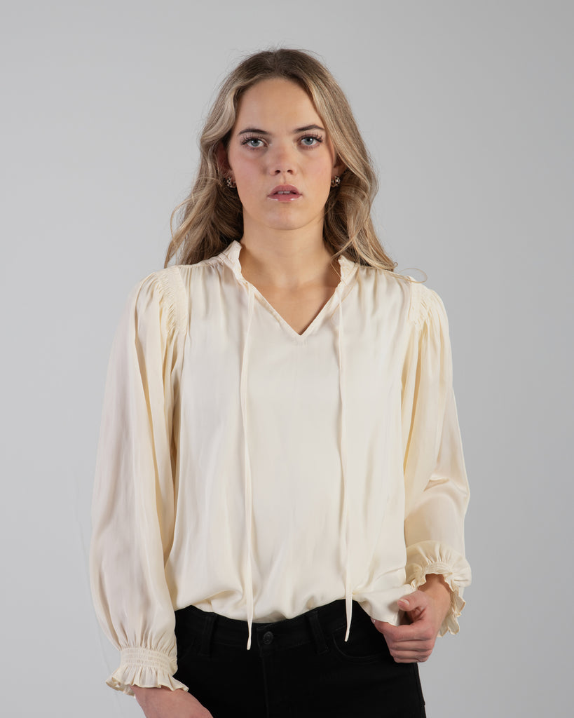 Woman in a white long sleeve v-neck blouse