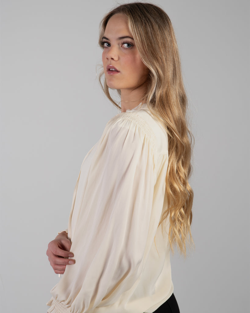 Woman in a white long sleeve v-neck blouse