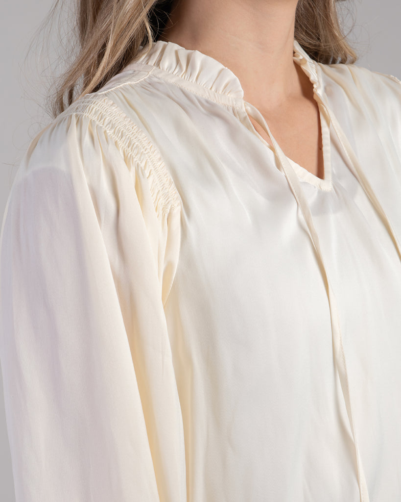 Woman in a white long sleeve v-neck blouse