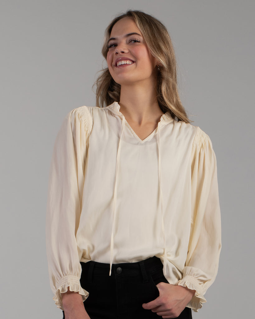 Woman in a white long sleeve v-neck blouse