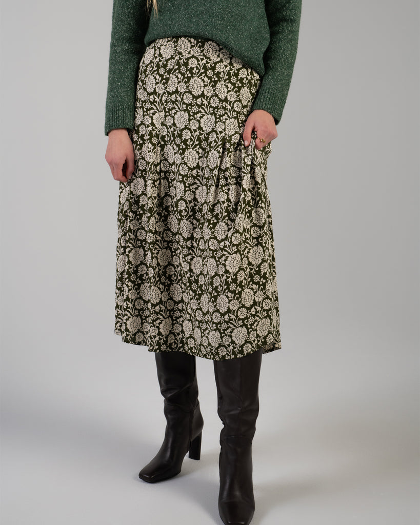 Woman in a green floral print midi length skirt