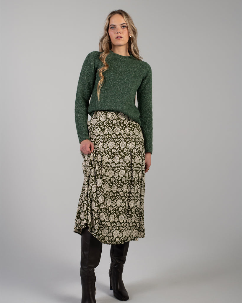 Woman in a green floral print midi length skirt