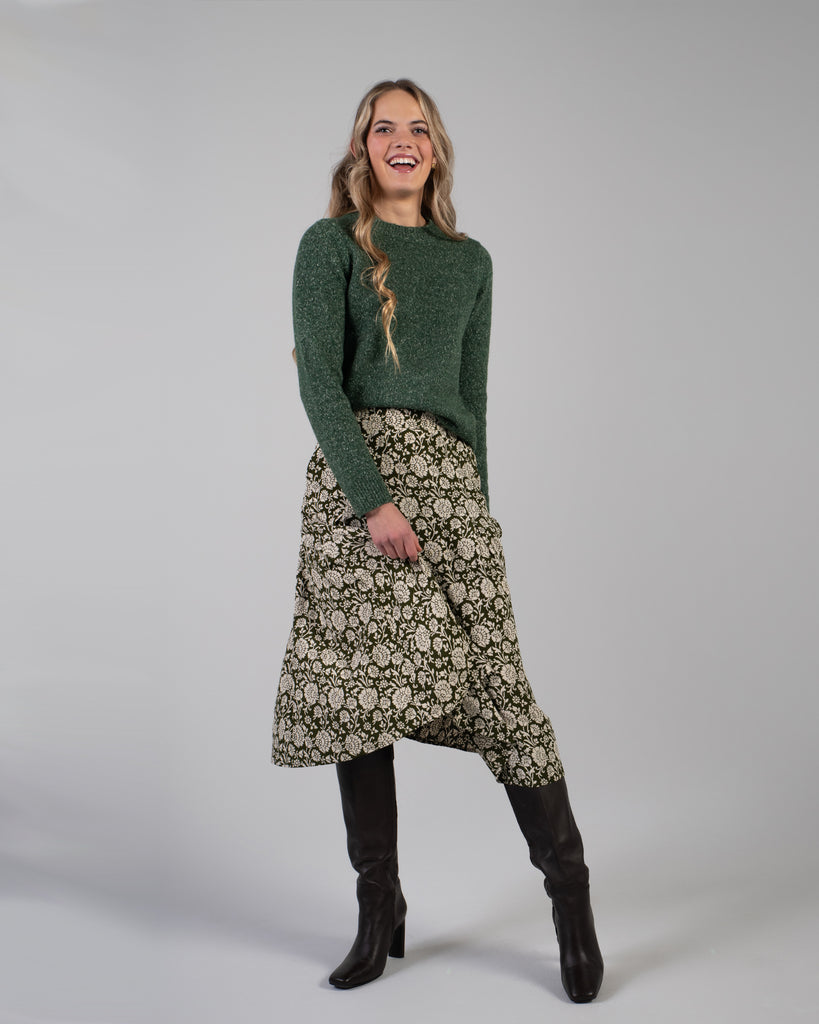 Woman in a green floral print midi length skirt