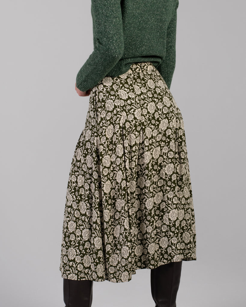 Woman in a green floral print midi length skirt