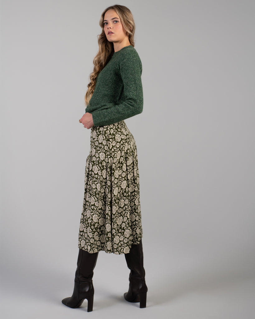 Woman in a green floral print midi length skirt