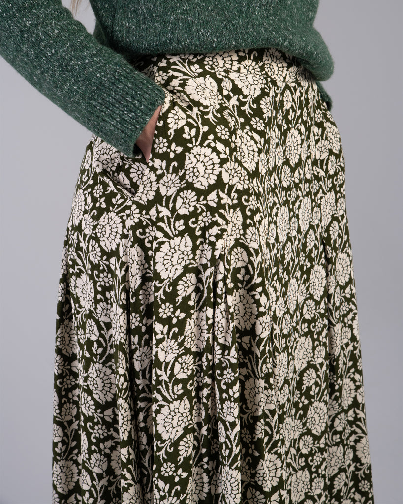 Woman in a green floral print midi length skirt