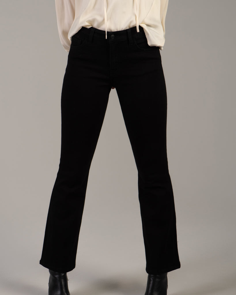 Model wearing black bootcut jeans that are ankle length.