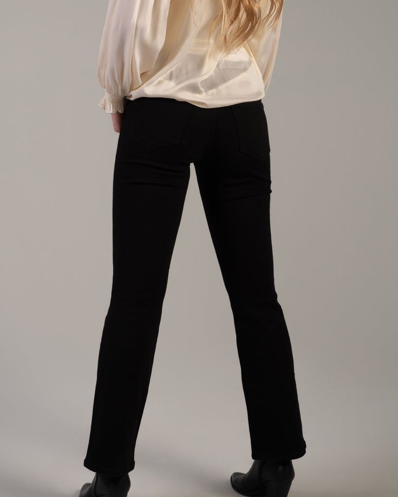 Model wearing black bootcut jeans that are ankle length.