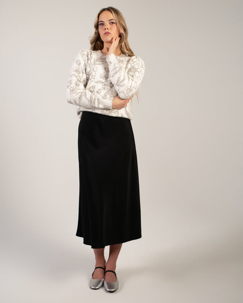 Woman in a black midi length slip skirt