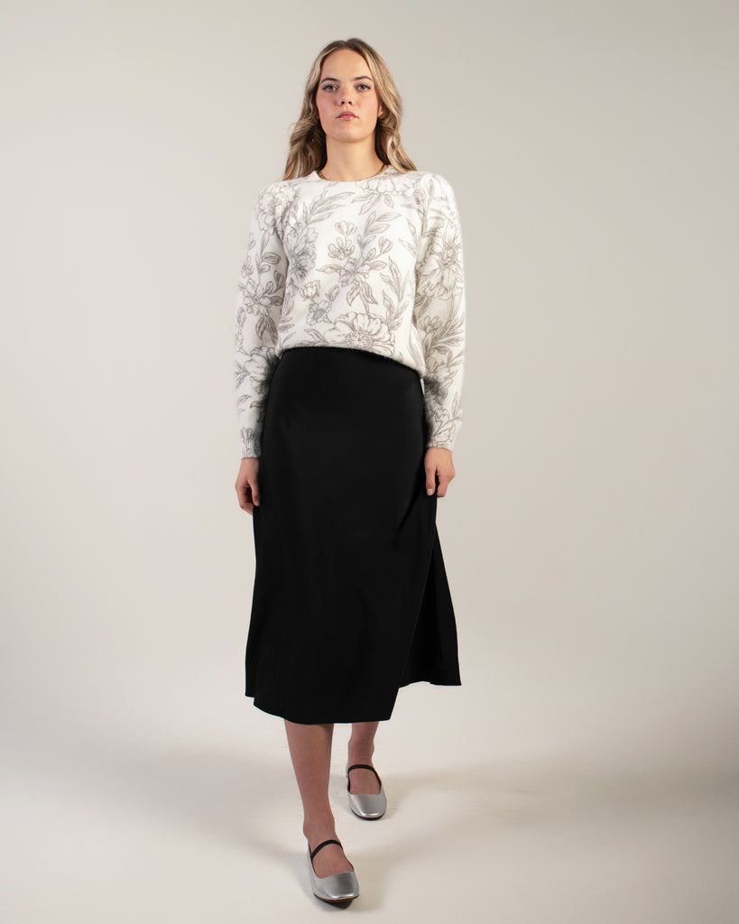 Woman in a black midi length slip skirt