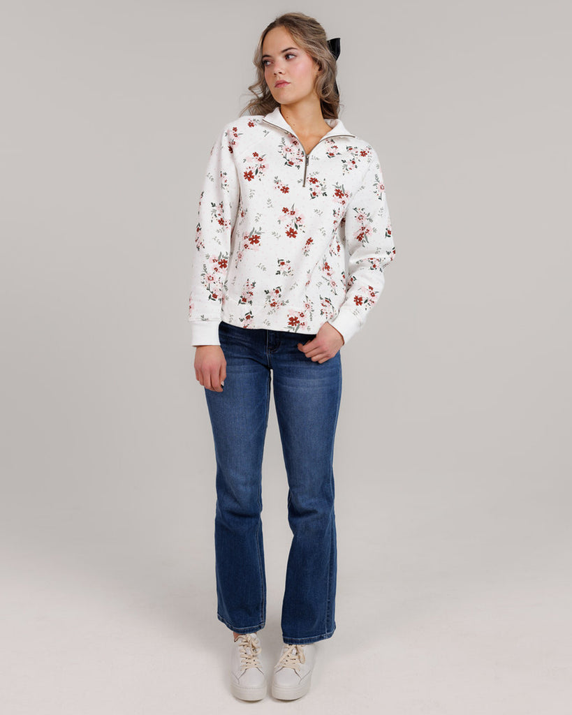 Model wearing a white with pink and red flowers, long sleeve, quarter zip sweatshirt.