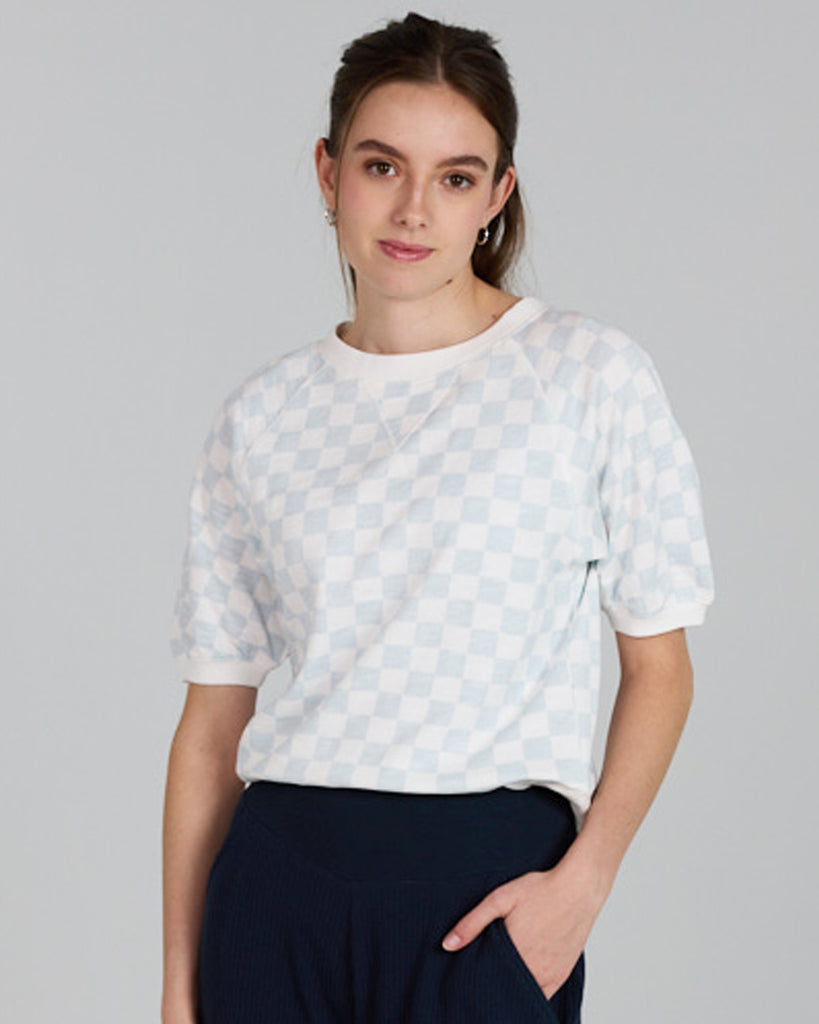 Model wearing a white and blue check short sleeve crew neck t-shirt.