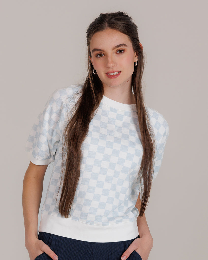 Model wearing a white and blue check short sleeve crew neck t-shirt.