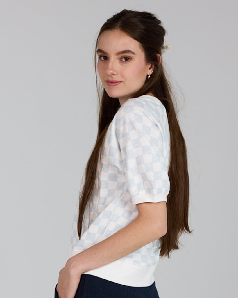 Model wearing a white and blue check short sleeve crew neck t-shirt.