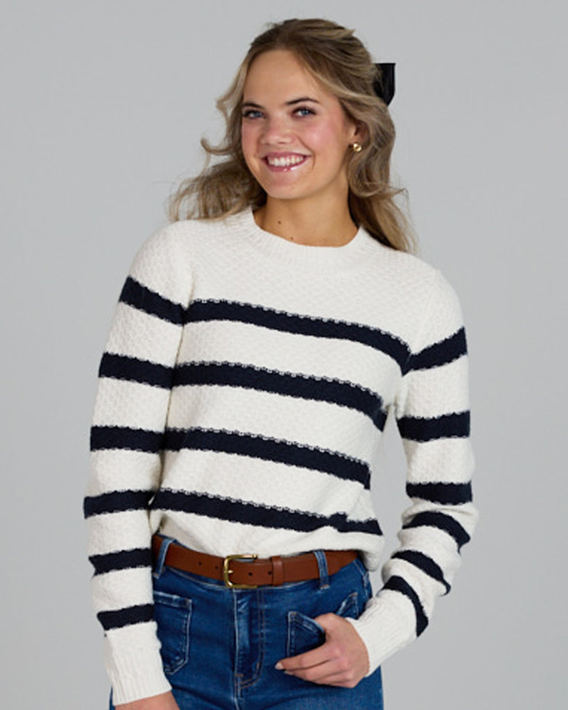 Model wearing a white with navy stripes long sleeve crew neck pullover sweater.