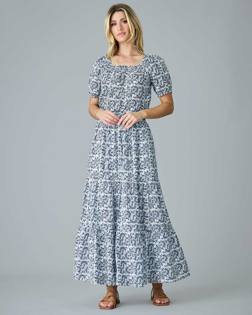 Model wearing a blue and white paisley print short sleeve, square neck, boxy blouse.