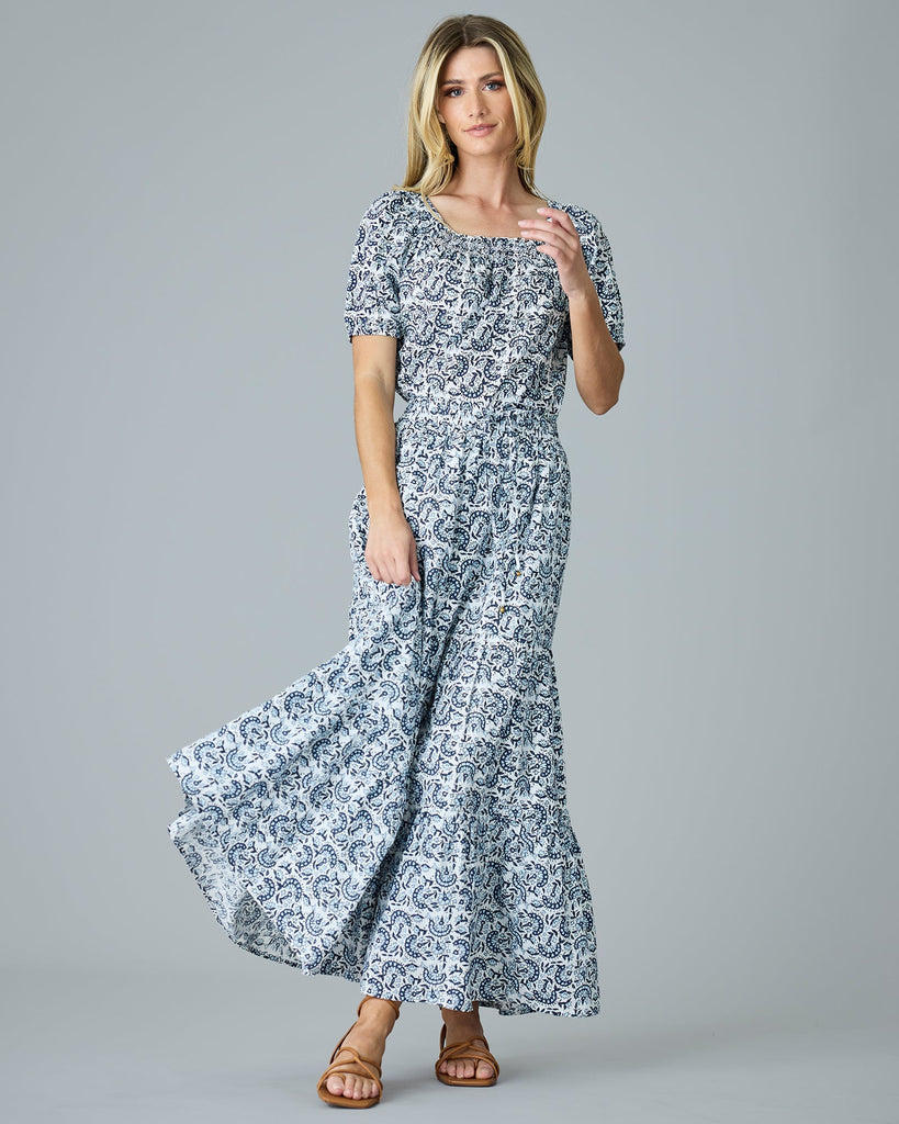 Model wearing a blue and white paisley print short sleeve, square neck, boxy blouse.