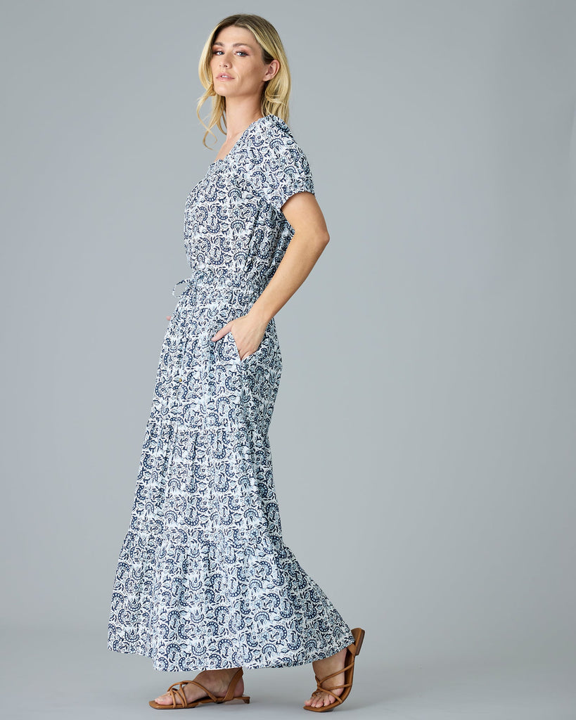 Model wearing a blue and white paisley print short sleeve, square neck, boxy blouse.