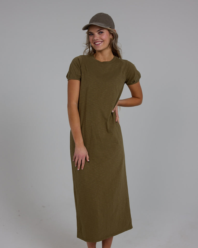 Model wearing an olive green short sleeve, crew neck, midi-length knit dress.