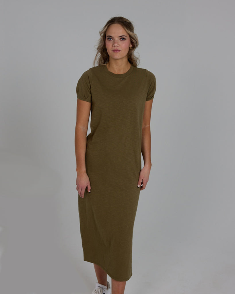 Model wearing an olive green short sleeve, crew neck, midi-length knit dress.