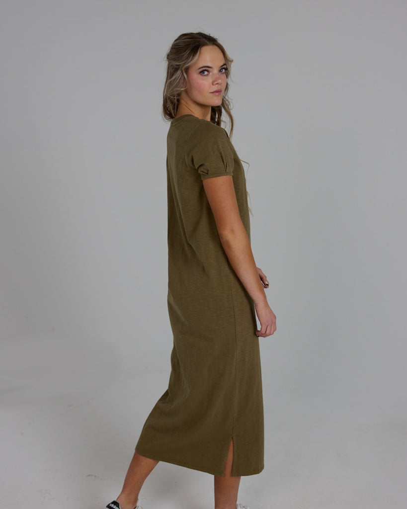 Model wearing an olive green short sleeve, crew neck, midi-length knit dress.